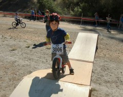 A toddler on a push bike rides the ramp at Take a Kid Mountain Biking Day